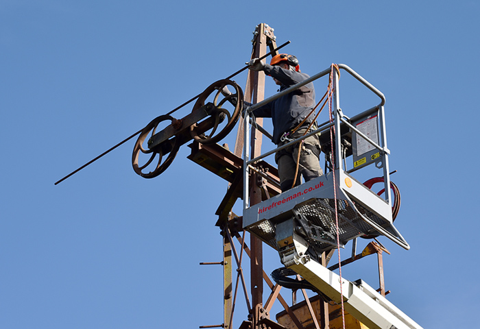 Balancing the pulleys with a length of rebar.